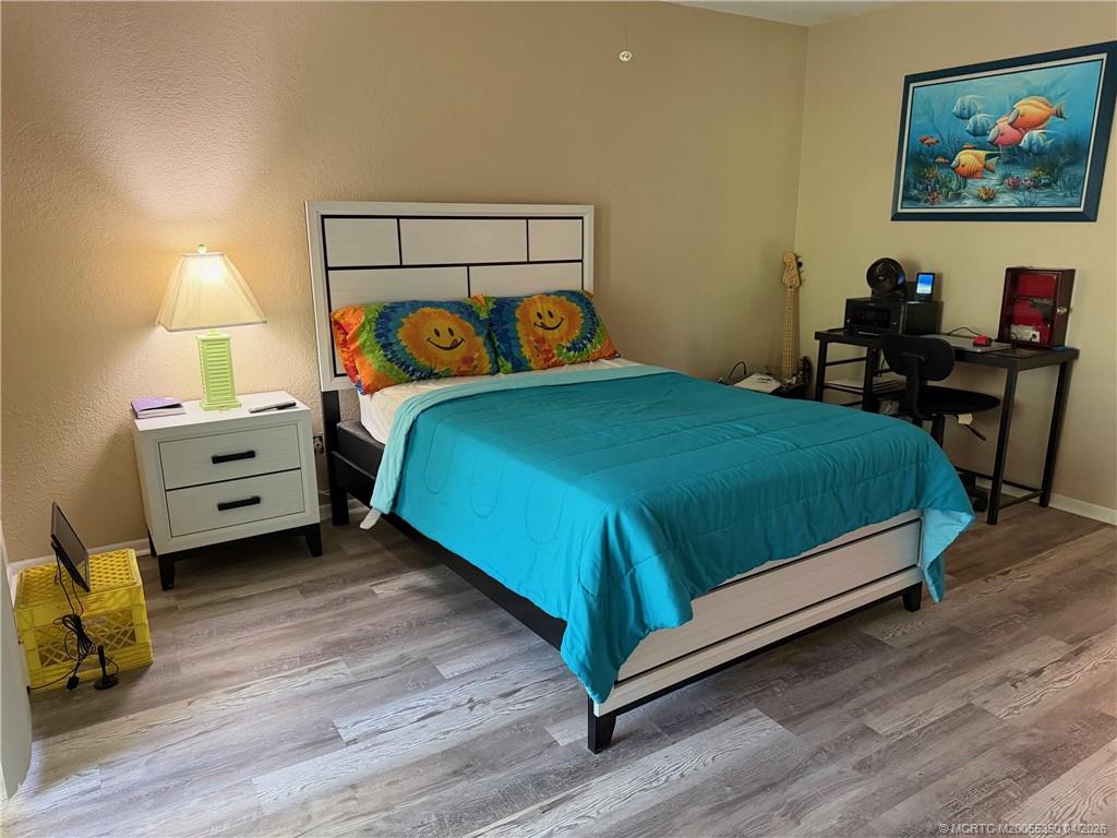 1225 Northwest 21st Street, Unit 3211 Stuart, FL 34994 - Photo 16 of 33 a bedroom with a bed and a lamp on table
