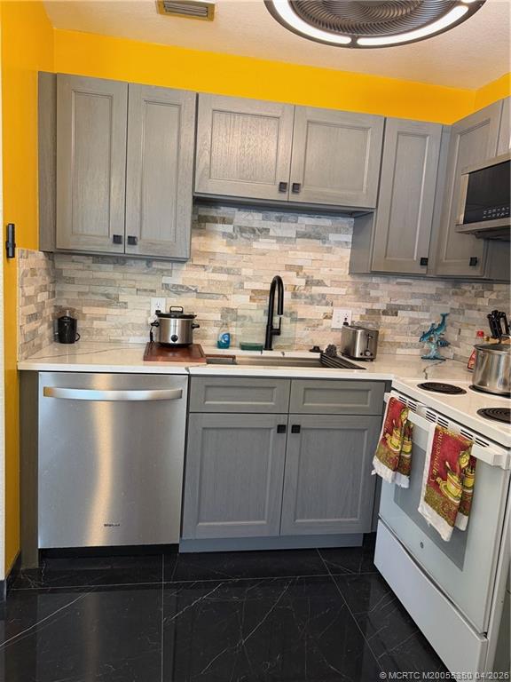 1225 Northwest 21st Street, Unit 3211 Stuart, FL 34994 - Photo 6 of 33 a kitchen with stainless steel appliances granite countertop a sink a stove and white cabinets