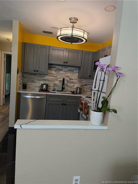 1225 Northwest 21st Street, Unit 3211 Stuart, FL 34994 - Photo 8 of 33 a kitchen with stainless steel appliances a sink a microwave a refrigerator and cabinets