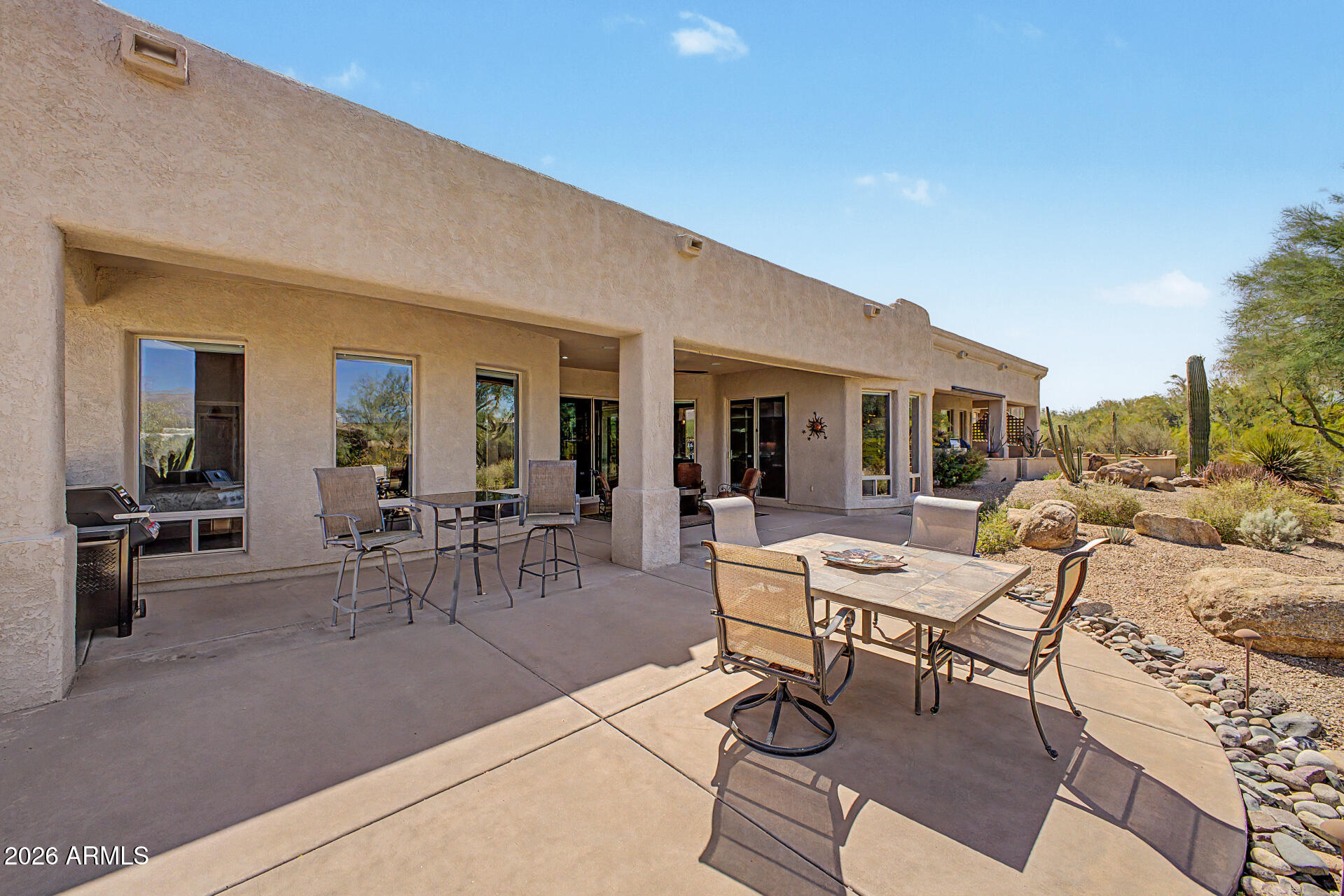27909 North Quail Spring Road Rio Verde, AZ 85263 - Photo 34 of 52 a view of a patio with dining table and chairs with potted plants