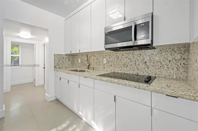 a kitchen with stainless steel appliances granite countertop a sink and a microwave