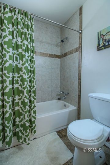708 West Perdew Avenue Ridgecrest, CA 93555 - Photo 20 of 37 a white toilet sitting next to a bath tub and a shower
