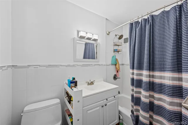 a bathroom with a sink a toilet and shower curtain