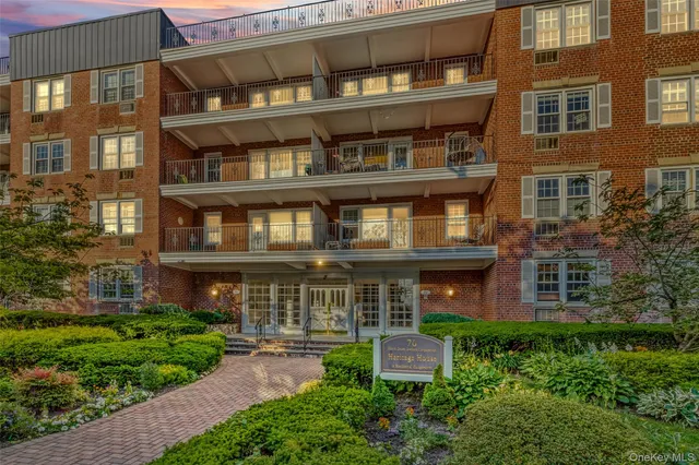 a front view of a residential apartment building with a yard