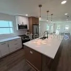 a kitchen with kitchen island a sink appliances and cabinets