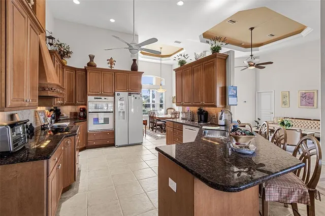 a kitchen with stainless steel appliances granite countertop a refrigerator a stove and a sink