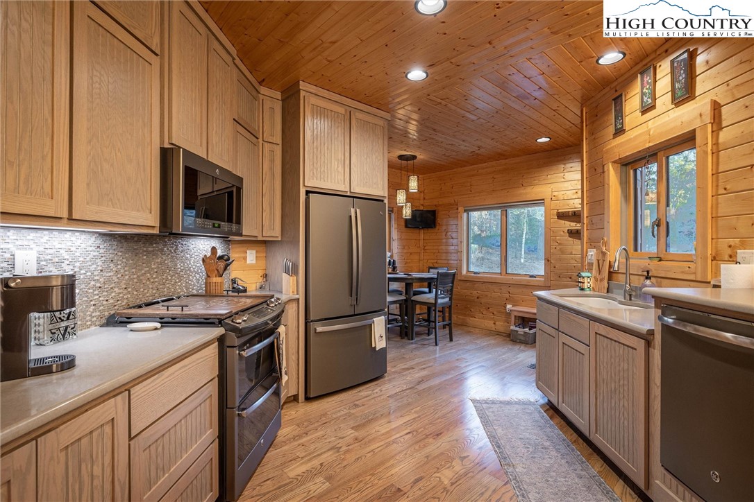 1989 Johns Ridge Parkway Lenoir, NC 28645 - Photo 12 of 50 a kitchen with stainless steel appliances granite countertop a stove top oven a sink dishwasher a refrigerator and cabinets with wooden floor