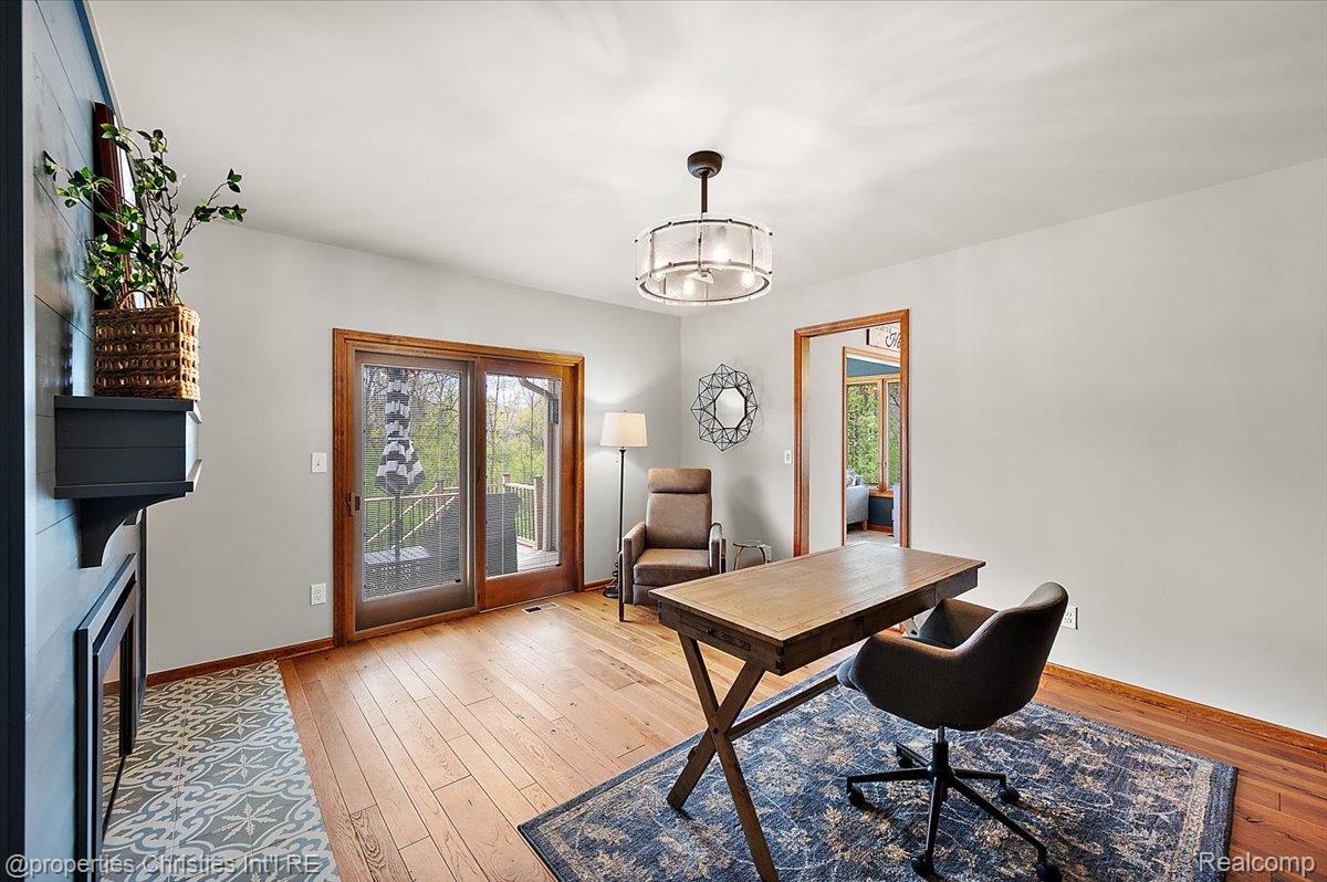 1071 Woodbridge Lane Rochester, MI 48306 - Photo 22 of 76 Office space featuring light wood-style flooring, a fireplace with flush hearth, and a chandelier