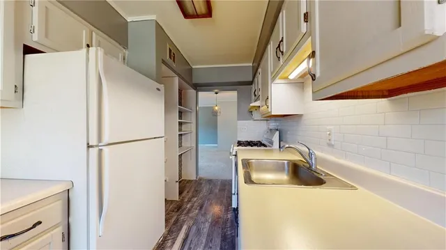 a bathroom with a sink a refrigerator and a sink
