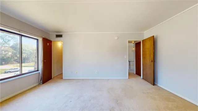 an empty room with windows and closet