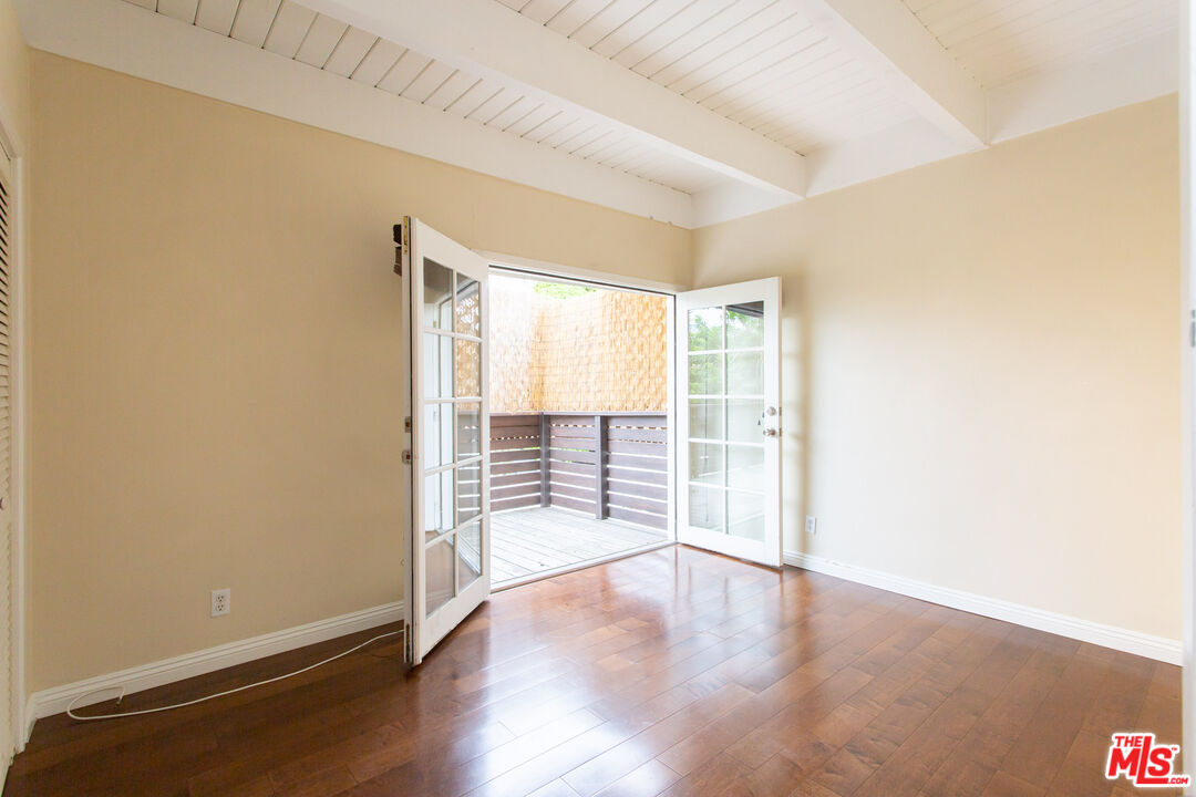 3900 Pacific Avenue Marina del Rey, CA 90292 - Photo 43 of 65 an empty room with wooden floor and windows with curtains