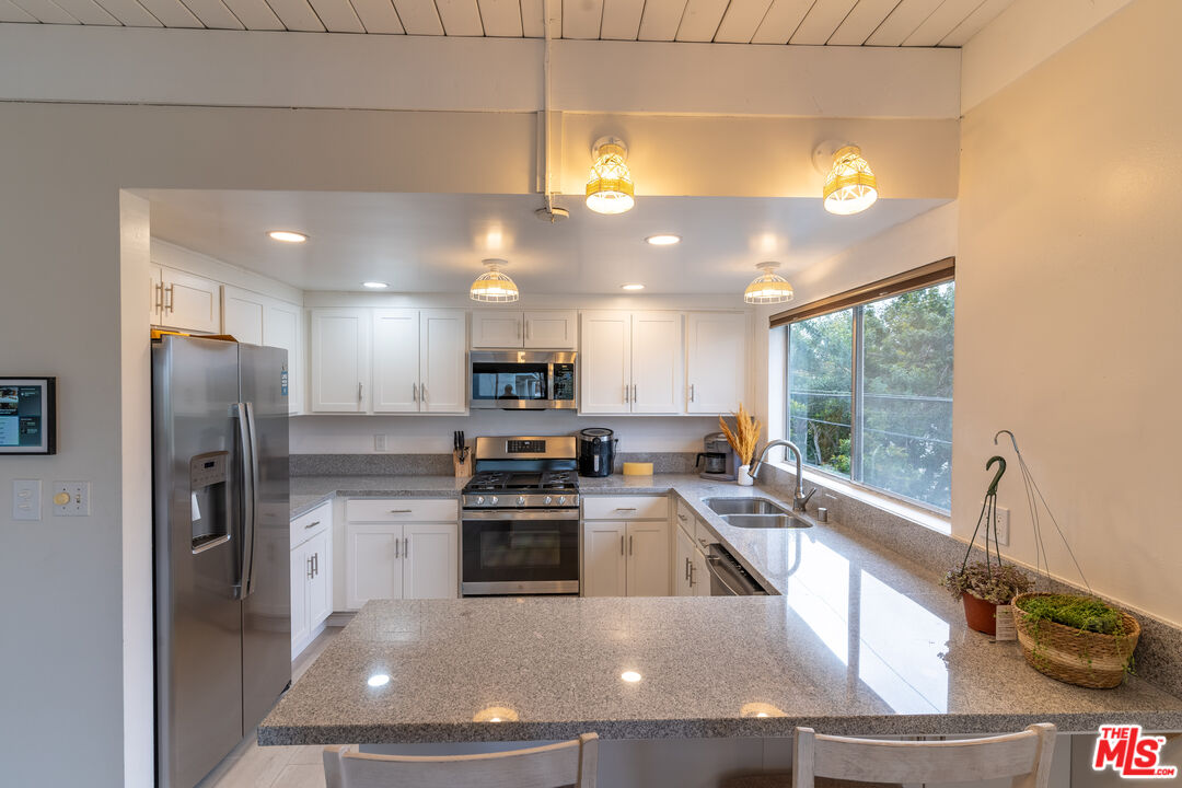 3900 Pacific Avenue Marina del Rey, CA 90292 - Photo 49 of 65 a kitchen with stainless steel appliances granite countertop a sink a stove and a refrigerator