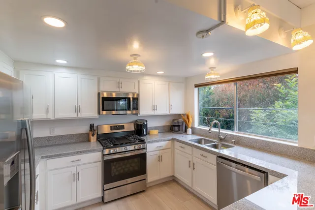 a kitchen with a sink a stove and cabinets