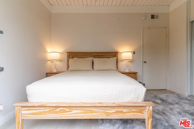 a bedroom with a bed and a night stand