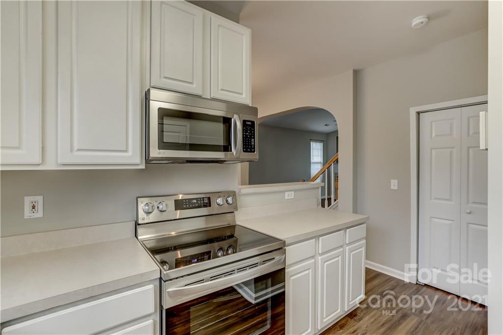 1121 Sienna Sand Way Fort Mill, SC 29708 - Photo 11 of 30 a kitchen with stainless steel appliances a stove a microwave and cabinets