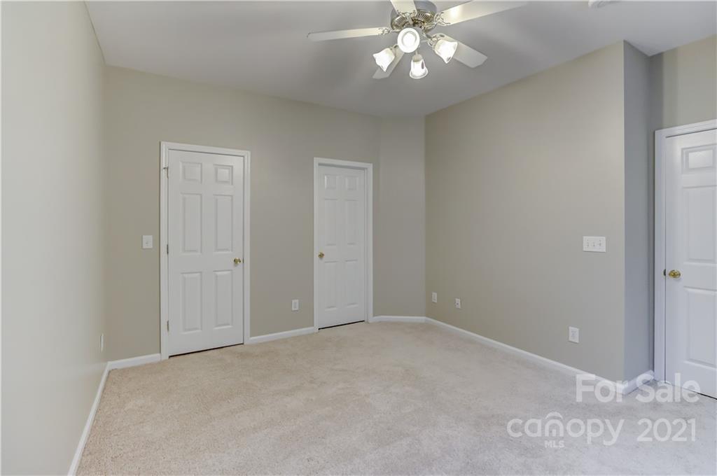 1121 Sienna Sand Way Fort Mill, SC 29708 - Photo 15 of 30 an empty room with a chandelier fan and windows