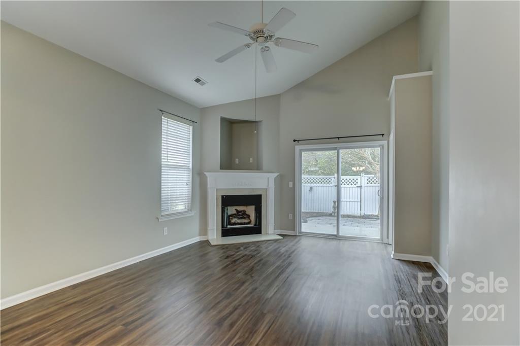 1121 Sienna Sand Way Fort Mill, SC 29708 - Photo 4 of 30 an empty room with windows a fireplace and wooden floor
