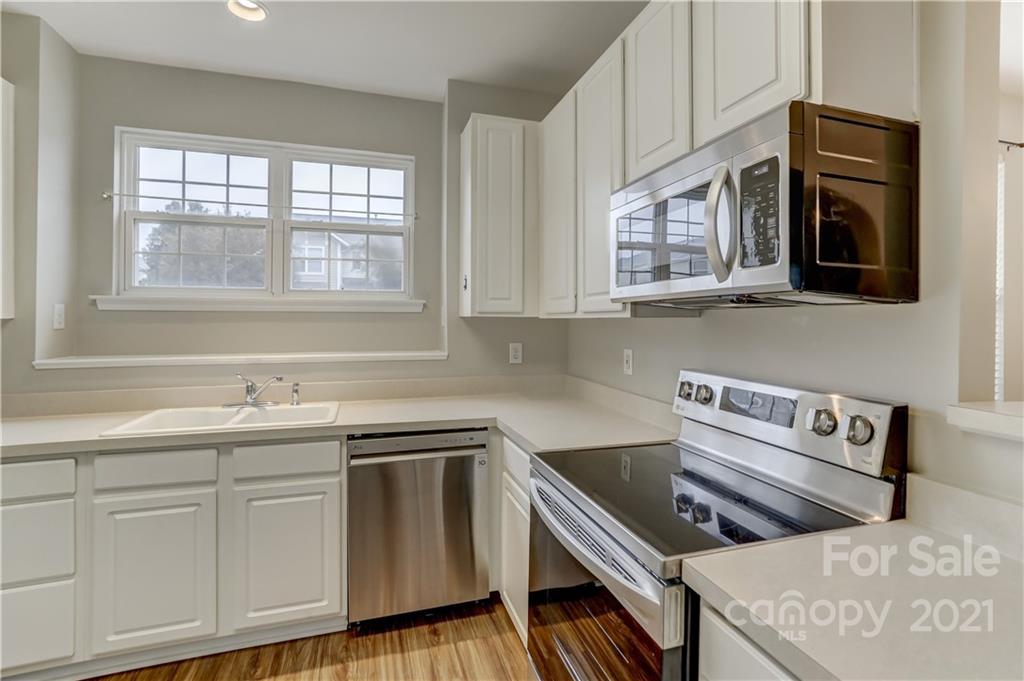 1121 Sienna Sand Way Fort Mill, SC 29708 - Photo 10 of 30 a kitchen with stainless steel appliances granite countertop a stove a sink and a microwave