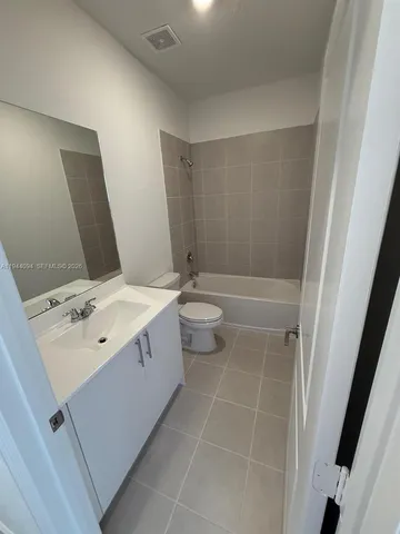 a bathroom with a double vanity sink toilet and mirror