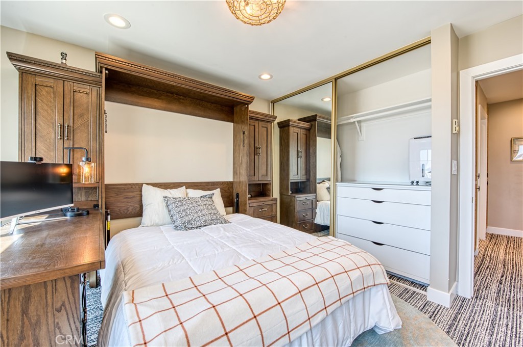 711 Pacific Coast Highway, Unit 421 Huntington Beach, CA 92648 - Photo 24 of 35 a bedroom with a large bed and a dresser