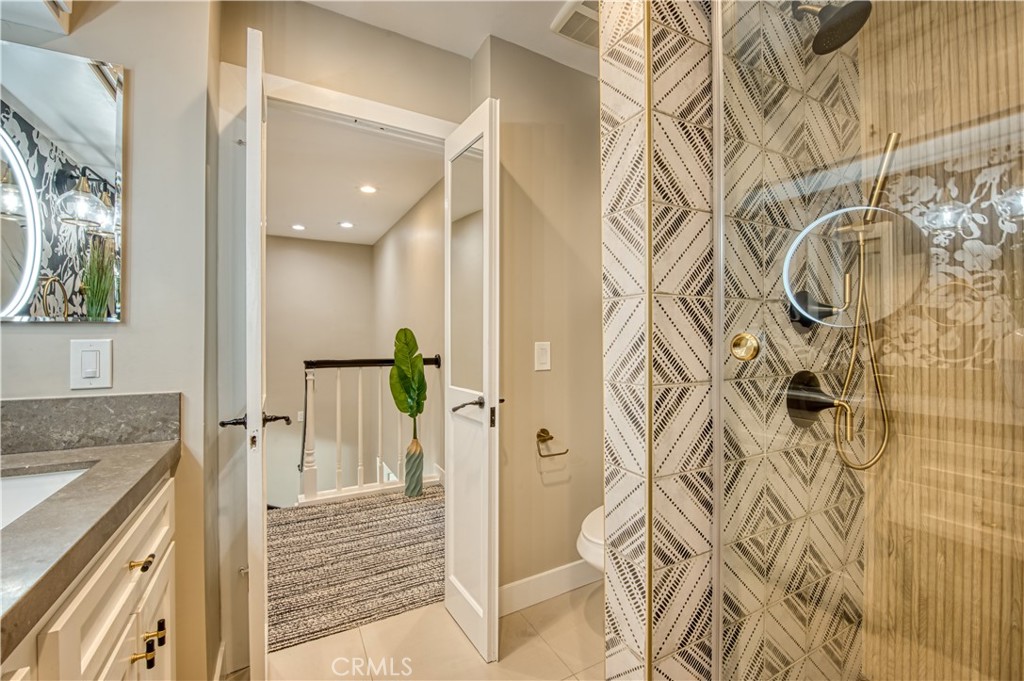 711 Pacific Coast Highway, Unit 421 Huntington Beach, CA 92648 - Photo 27 of 35 a bathroom with a granite countertop shower and a sink