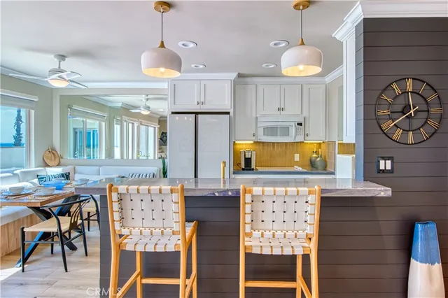 a kitchen with granite countertop kitchen island stainless steel appliances a table and chairs in it