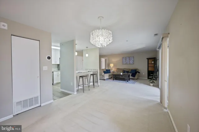 a view of a livingroom with kitchen and chandelier