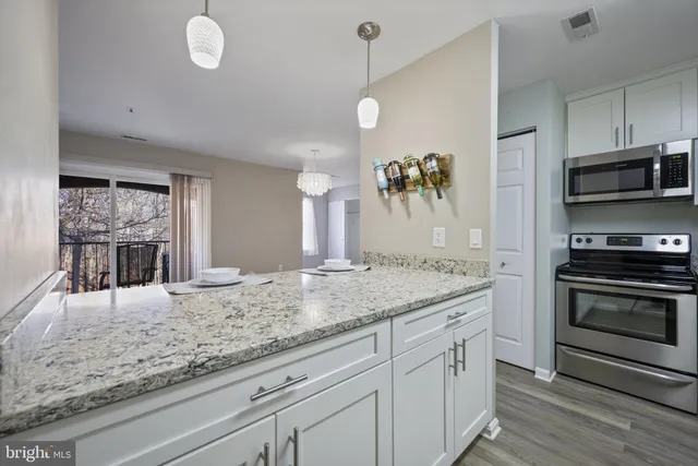 a kitchen with stainless steel appliances granite countertop a stove and cabinets