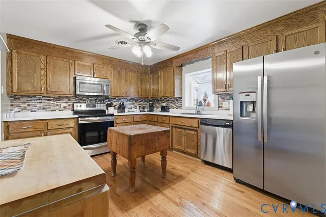 a kitchen with stainless steel appliances a sink cabinets and wooden floor