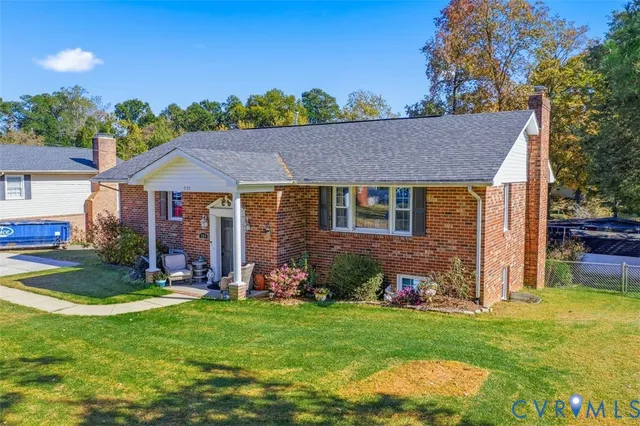 a view of a house with a yard potted plants and large tree