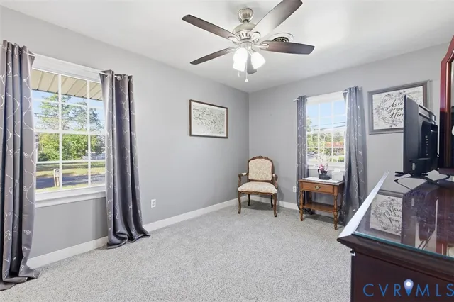 a living room with furniture two window and a ceiling fan