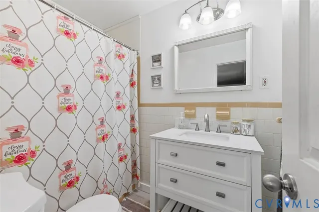 a bathroom with a sink vanity mirror and toilet