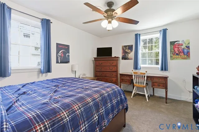 a bedroom with a bed and a dresser next to a window