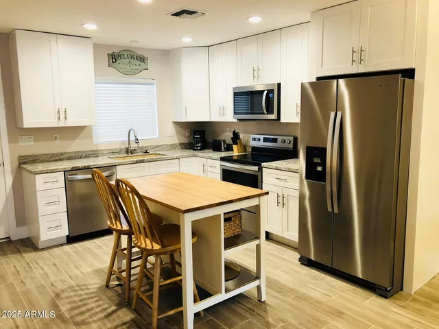 a kitchen with a refrigerator a stove a sink and a microwave