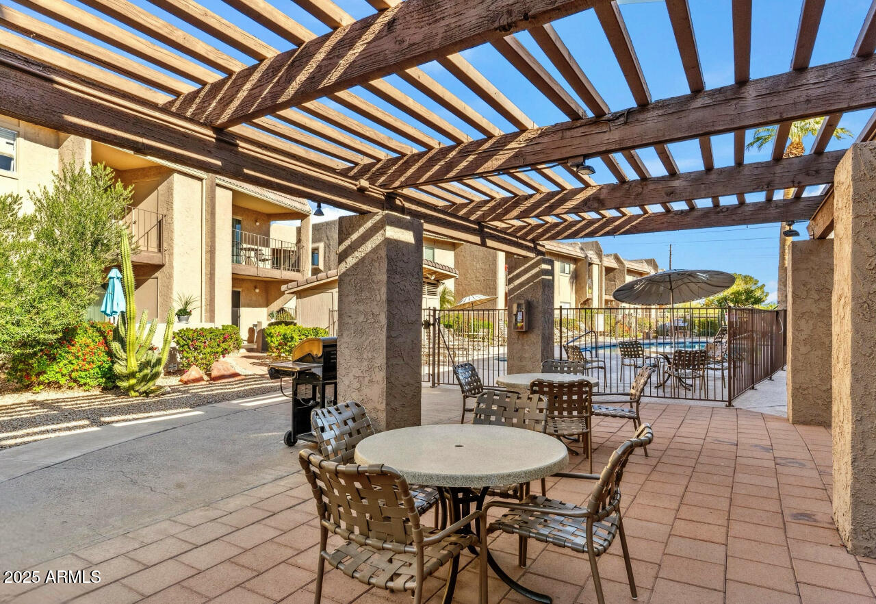 7436 East Chaparral Road, Unit 264B Scottsdale, AZ 85250 - Photo 20 of 22 a view of a patio with a table and chairs and potted plants