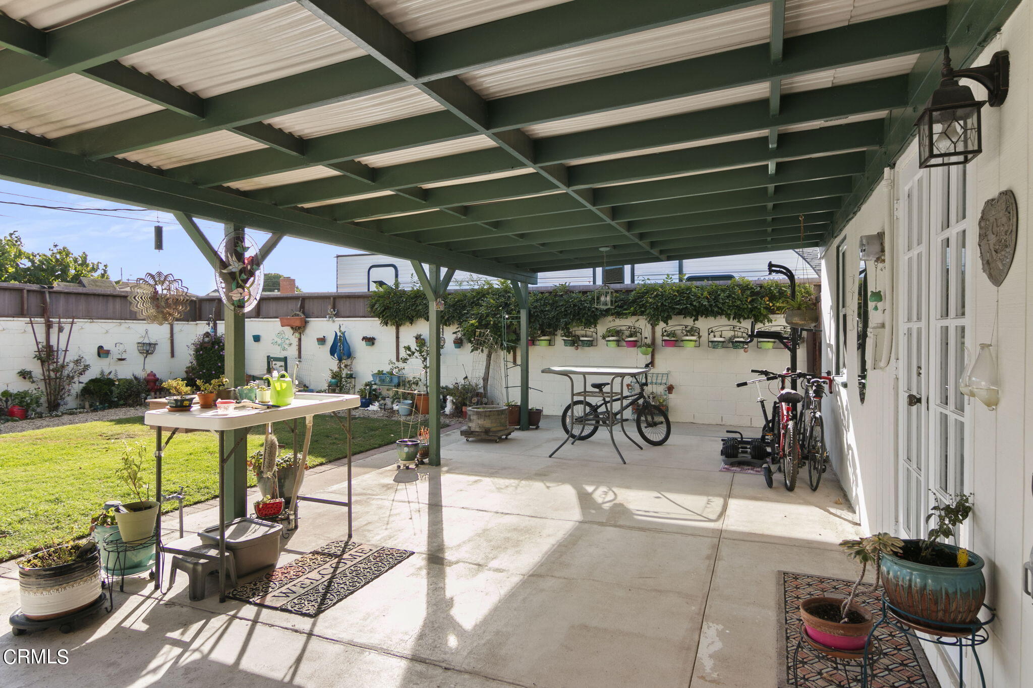 524 Nectarine Street Oxnard, CA 93033 - Photo 22 of 28 a view of a patio with table and chairs potted plants and large trees