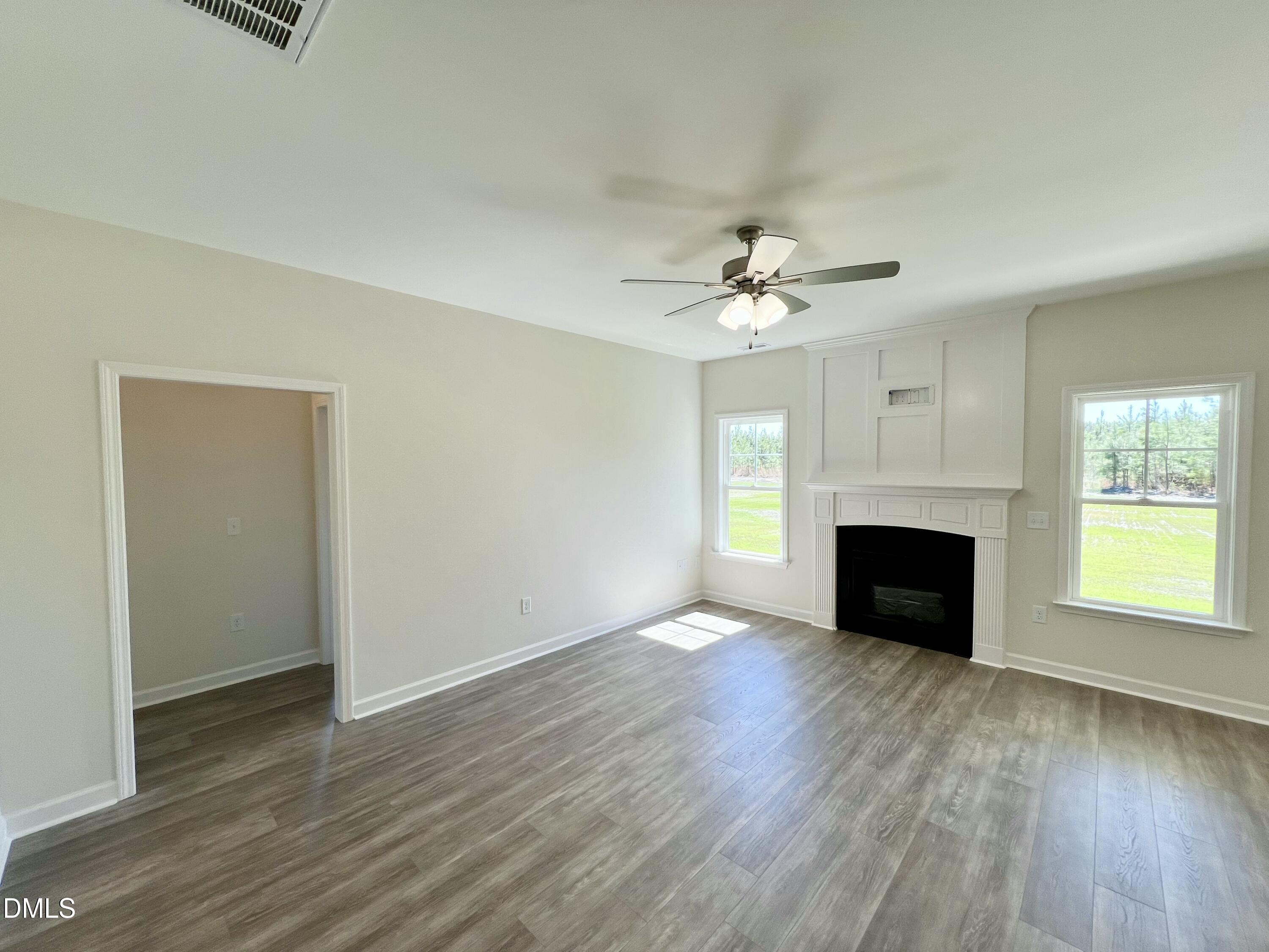 731 Polly Watson Road Fremont, NC 27830 - Photo 3 of 21 an empty room with windows a fireplace and wooden floor