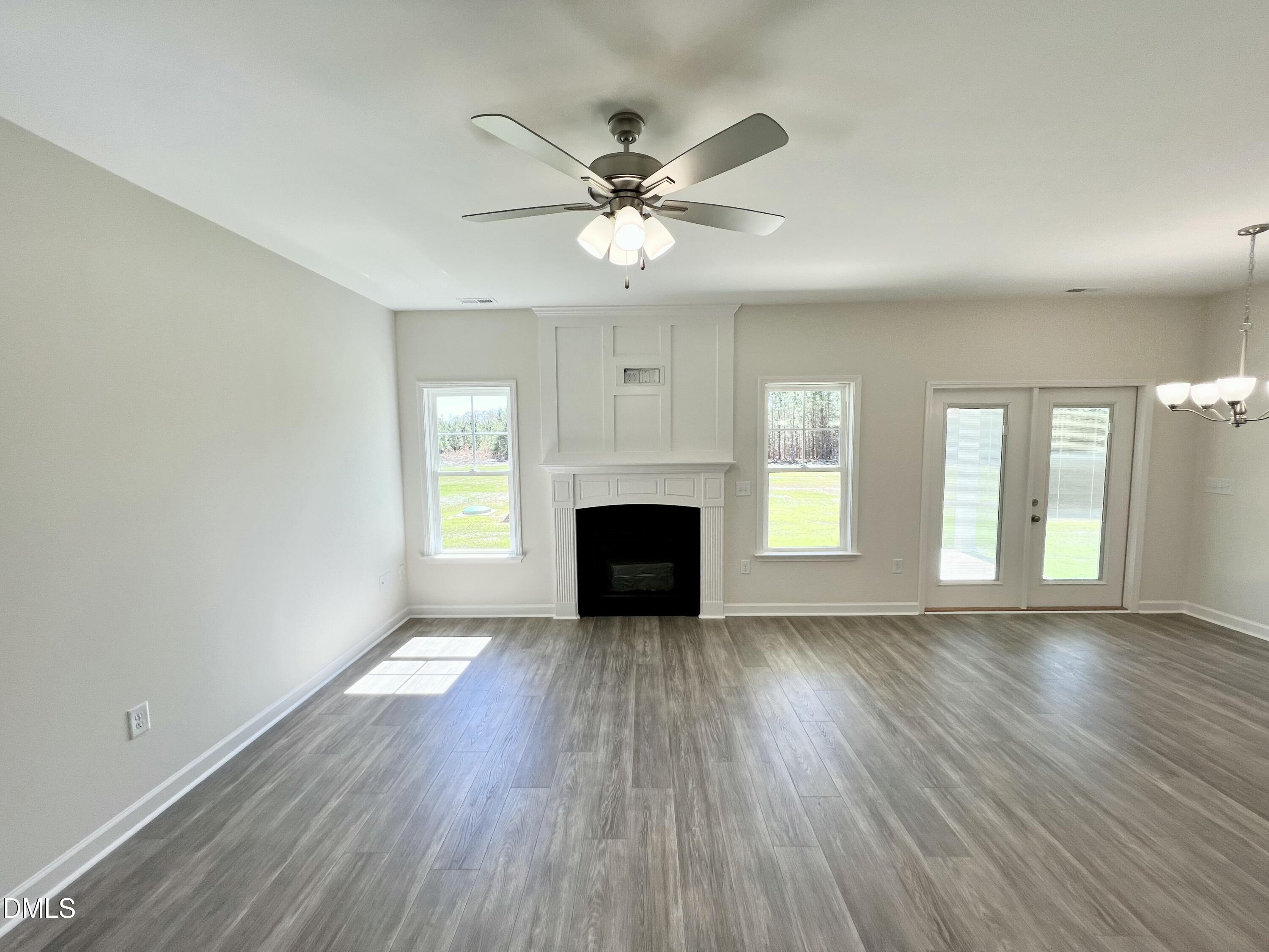 731 Polly Watson Road Fremont, NC 27830 - Photo 4 of 21 an empty room with wooden floor fireplace and windows