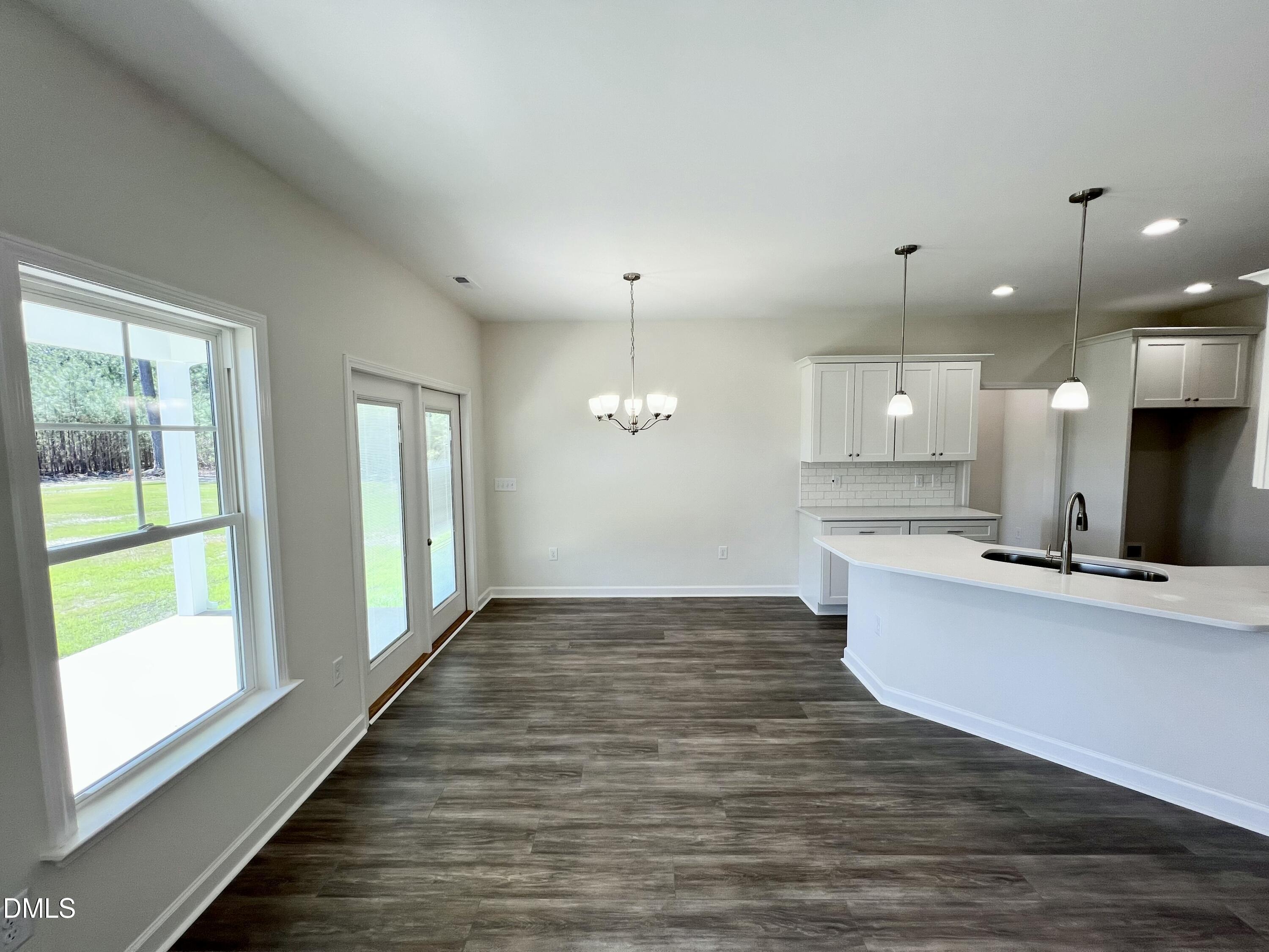 731 Polly Watson Road Fremont, NC 27830 - Photo 5 of 21 a view of a kitchen with kitchen island a sink wooden floor and a large window