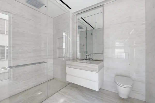 a bathroom with a granite countertop sink a toilet and shower