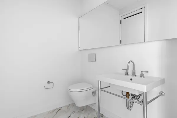 a bathroom with a toilet a sink and mirror