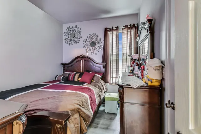 a bed room with a bed a flat screen tv and dresser