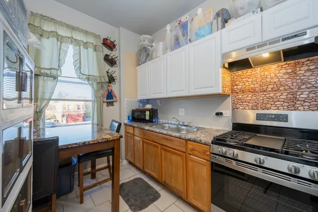 a kitchen with stainless steel appliances granite countertop a stove and white cabinets