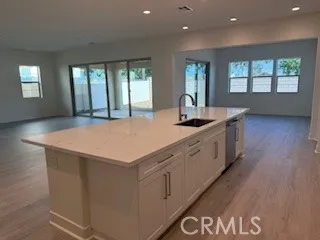 a kitchen with stainless steel appliances granite countertop a sink a stove and a wooden floors