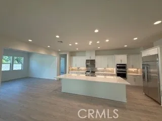 a large kitchen with a large counter top stainless steel appliances and cabinets