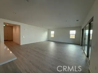 an empty room with windows and wooden floor