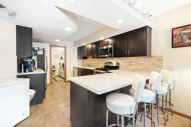 a kitchen with a table chairs refrigerator and microwave