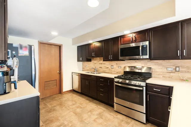 a kitchen with stainless steel appliances a stove sink microwave and refrigerator