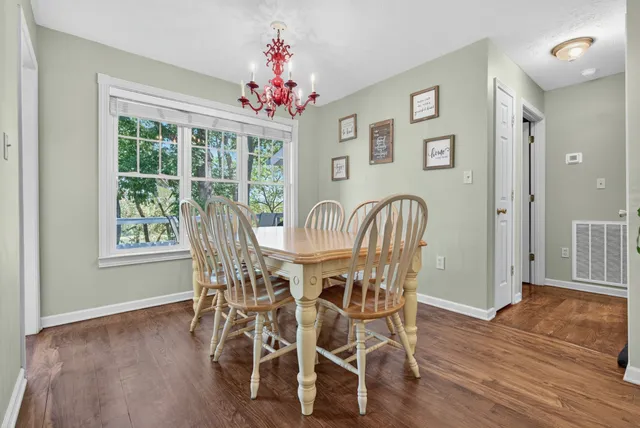 a kitchen with stainless steel appliances granite countertop a refrigerator a sink dishwasher and white cabinets with wooden floor