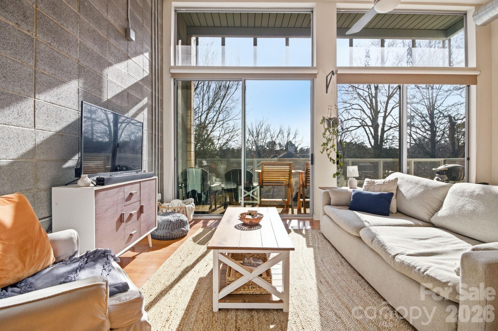 a living room with furniture a large window and a table